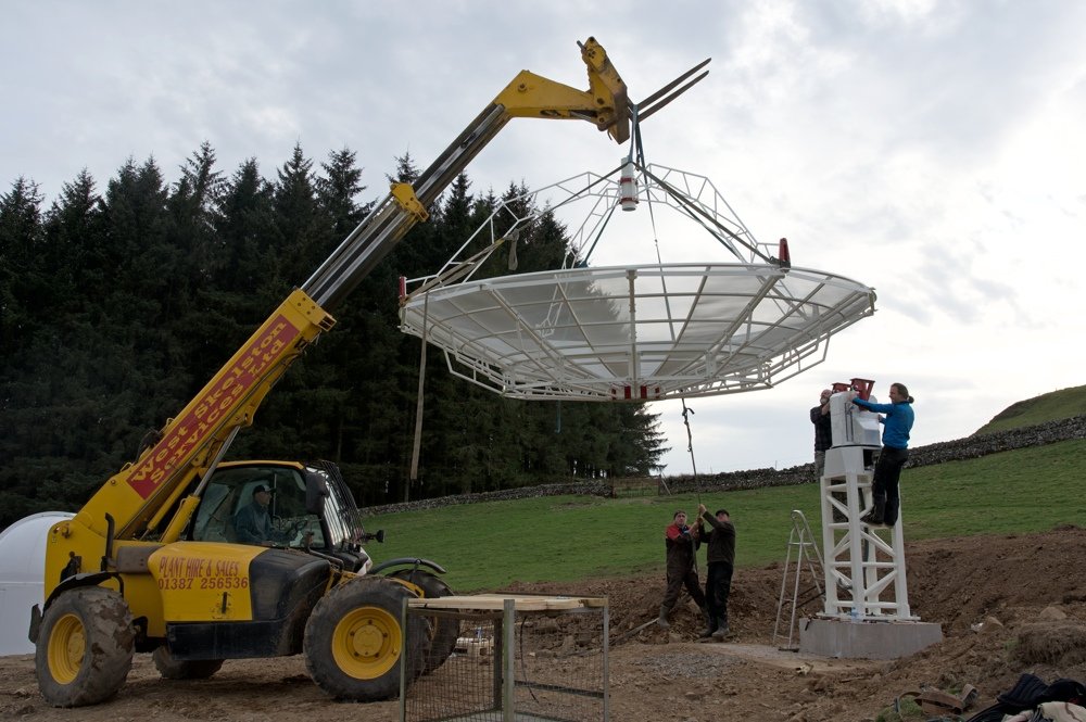 SPIDER 500A radio telescope installed in Scotland: with the help of a lift machine, the antenna is installed on the mount